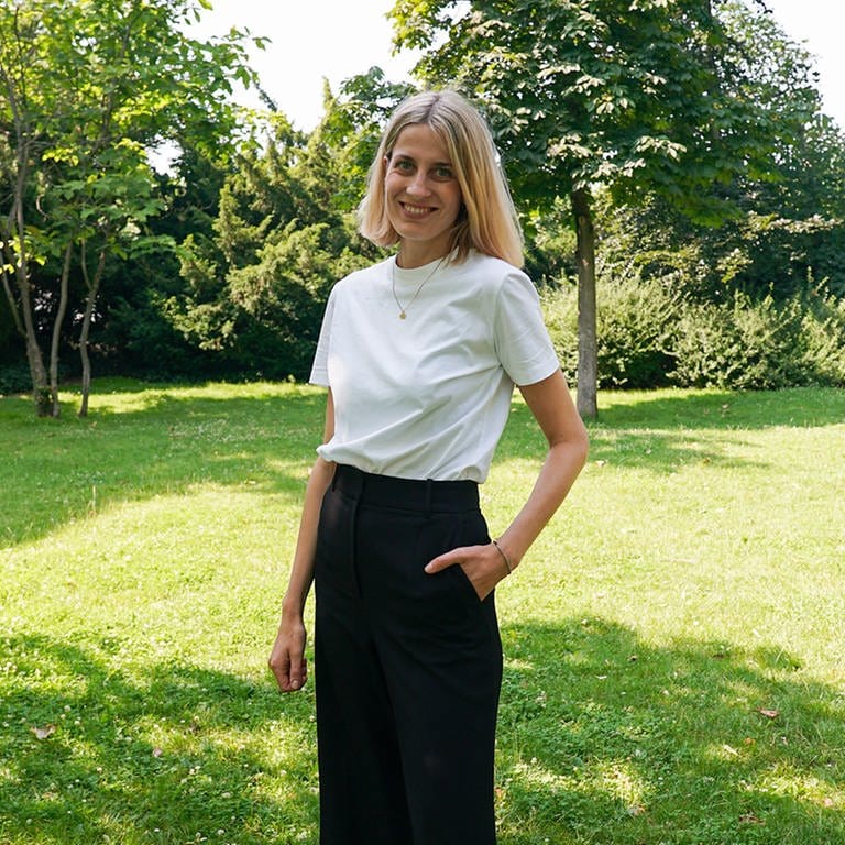 Hannah, Gründerin eines nachhaltigen Modelabels, steht auf einer grünen Wiese.  (Foto: SWR)
