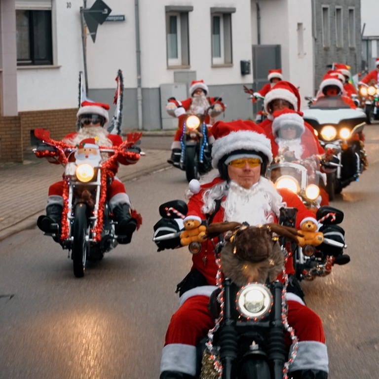 In roten Weihnachtsmänner Kostümen fahren die sogenannten "Riding Santas" auf ihren Motorrädern eine Straße entlang. (Foto: SWR)