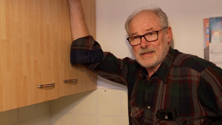 Manfred vom Verein „Alt-Arm-Allein“ lehnt an einem Küchenschrank. Er hilft ehrenamtlich älteren Menschen bei Handwerksarbeiten. (Foto: SWR)