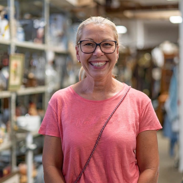 Silke Schulz lacht in die Kamera. Sie bietet Haushaltsauflösungen und Entrümpelungen in Worms an und betreibt dort das „Kaufhaus der Wiederkehr“, wo Secondhandartikel verkauft werden. (Foto: SWR)