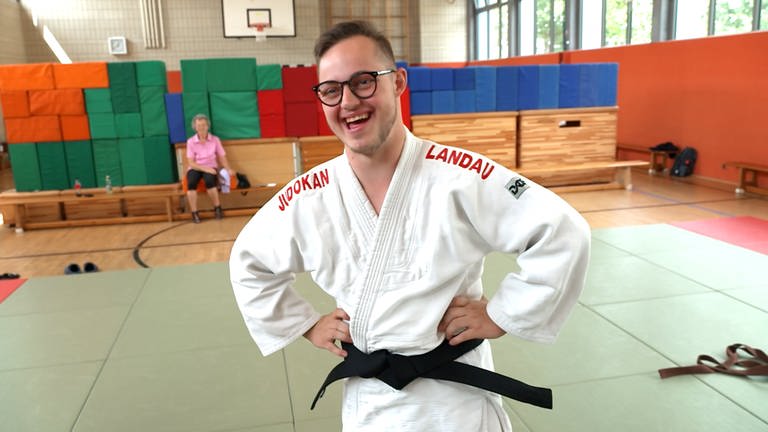 Sich freuender junger Mann mit Judo-Anzug und schwarzem Gürtel. (Foto: SWR)