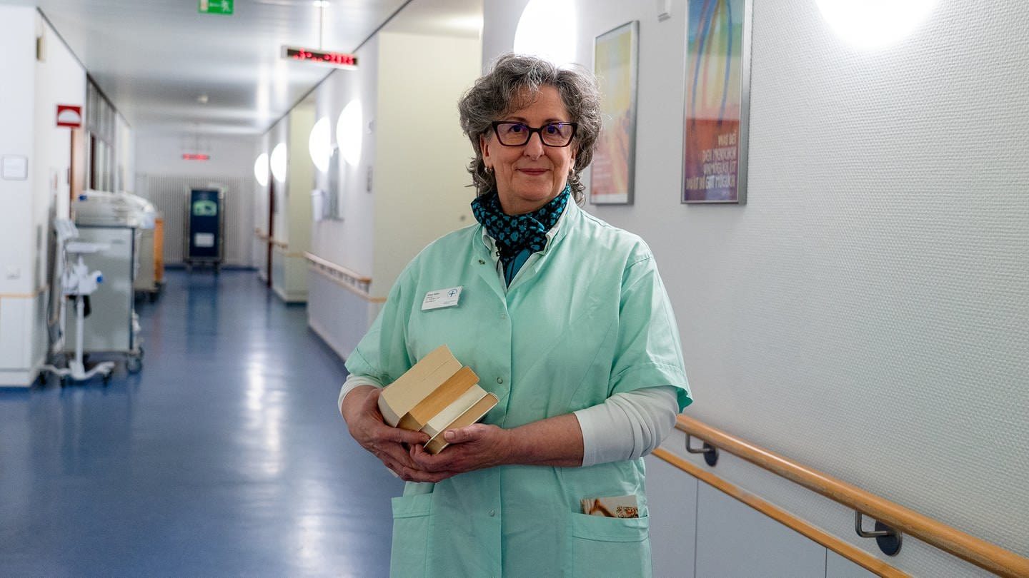 Eine Frau steht in einem Kittel im Flur eines Krankenhauses. Sie ist Grüne Dame im Evangelischen Krankehaus Bad Dürkheim. (Foto: SWR)
