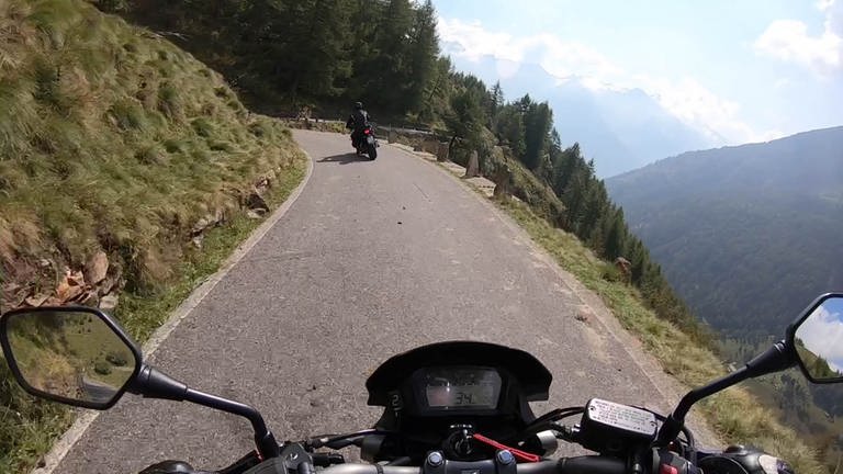 Bild aus Sicht eines Motorradfahrers, der durch eine Landschaft von hohen Bergen fährt. (Foto: SWR)