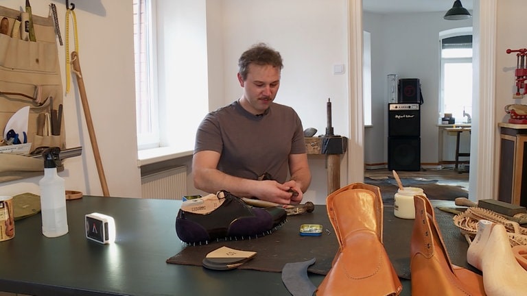 Junger Mann in Atelier fertig Maßschuhe.