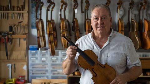 Geigenbauer Peter Körner mit Geige in der Hand (Foto: SWR)