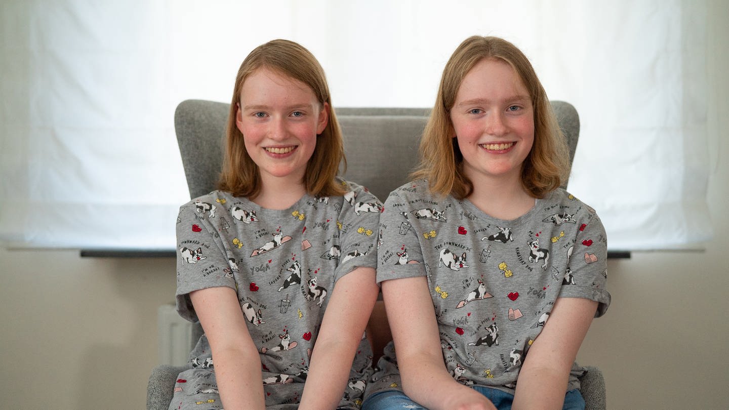 Jugendliche Zwillingsgeschwister mit den rötlichen Haaren sitzen auf einem Sessel