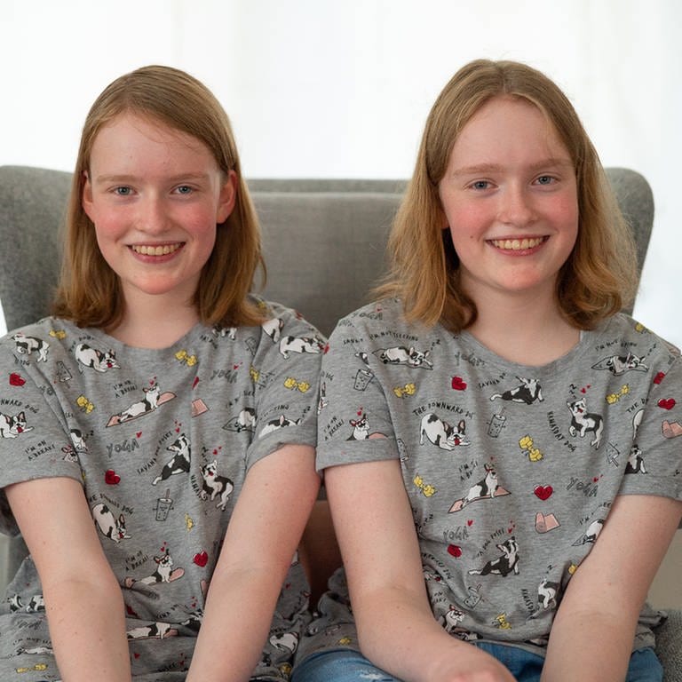 Jugendliche Zwillingsgeschwister mit den rötlichen Haaren sitzen auf einem Sessel (Foto: SWR)