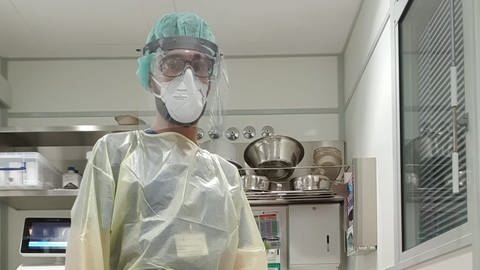 Krankenpfleger einer Covid-19-Intensivstation mit spezieller Schutzkleidung. 