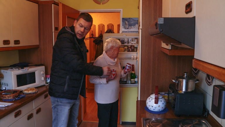 Mann, Anfang 50, hilft Seniorin mit ihrem Einkauf (Foto: SWR)