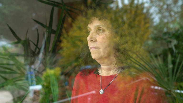 Traurige Frau steht an einem Fenster und blickt in die Ferne (Foto: SWR)