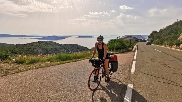 Junge Frau auf ihrem Rad. Im Hintergrund die Küste von Kroatien mit ihren Inseln.  (Foto: SWR)