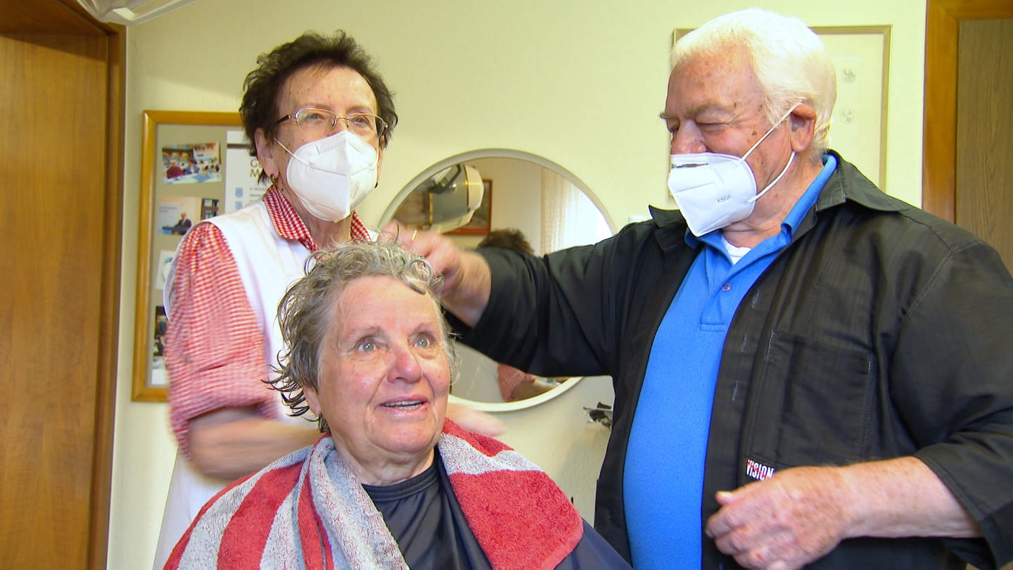 Ein altes Ehepaar schneidet einer Kundin in ihrem Salon die Haare (Foto: SWR)