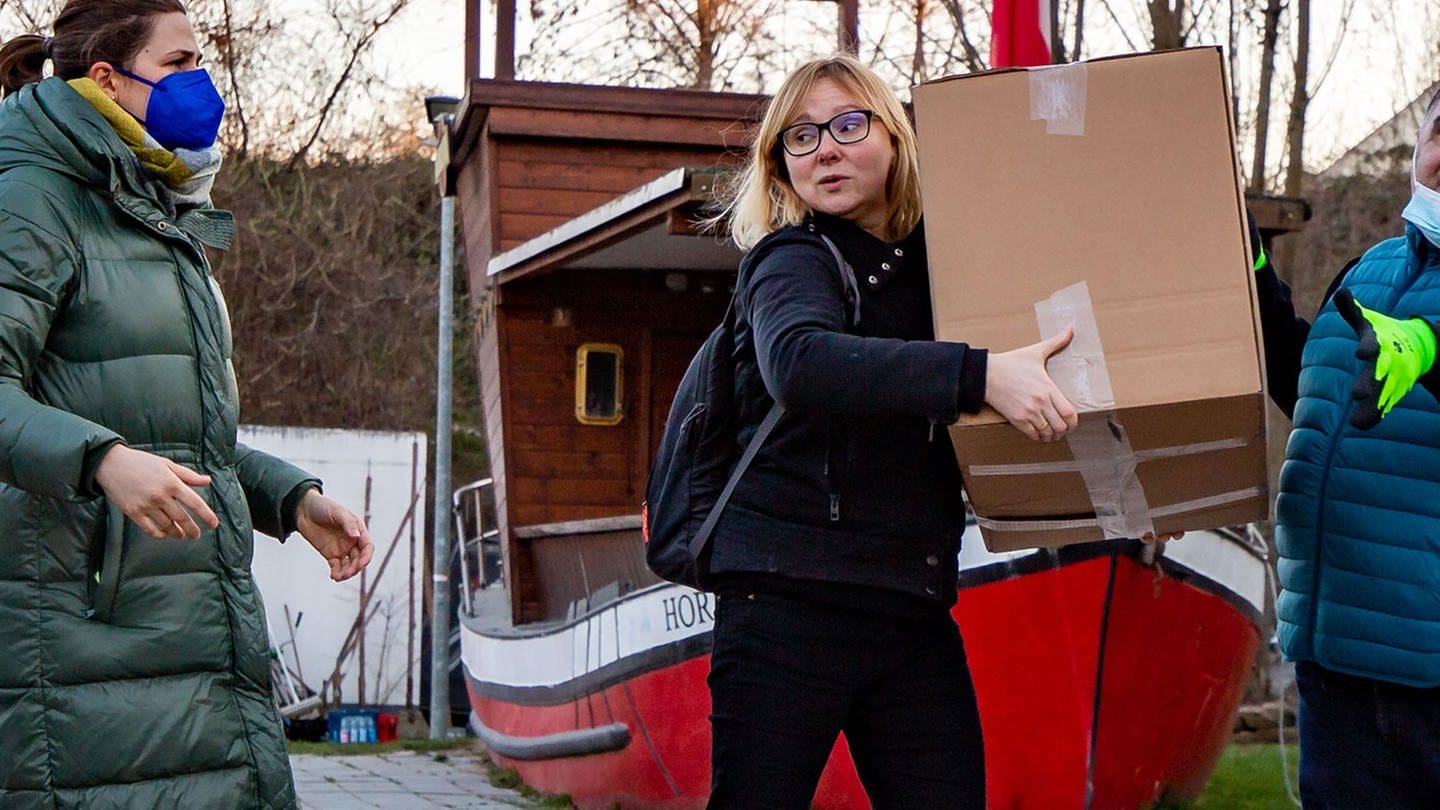 Frau trägt Pakete die Hilfgüter für Ukraine sind