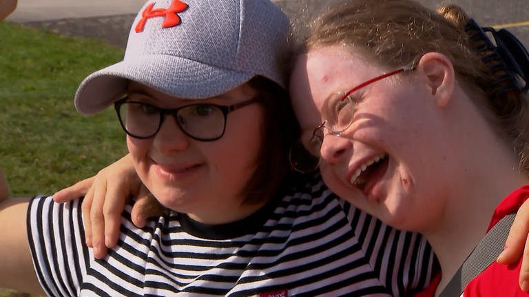 Zwei junge Frauen mit Brille lächeln und lehnen Arm in Arm aneinander. (Foto: SWR)