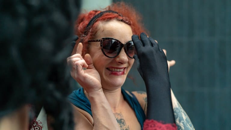 Rothaarige Frau bekommt Sonnenbrille angezogen (Foto: SWR)