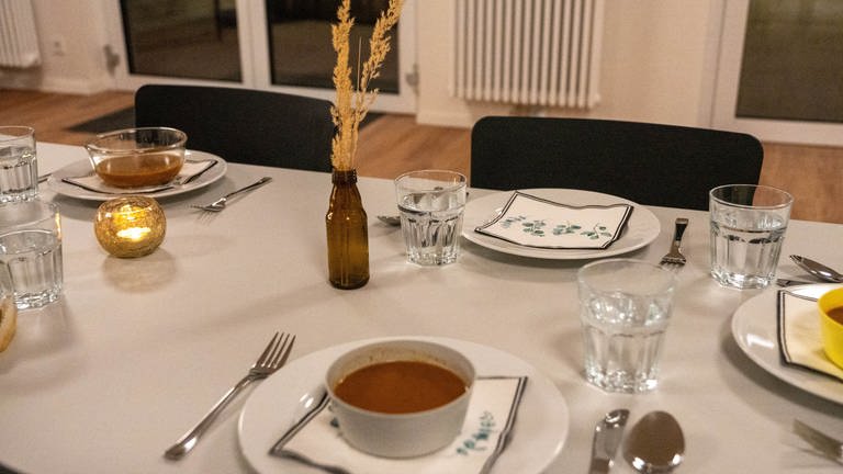 Ein gedeckter Tisch mit Geschirr und Dekoration.
