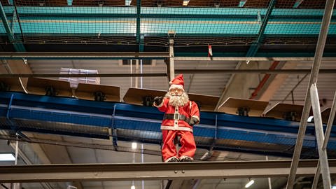 Weihnachtsmann hängt an Förderband im DHL-Paketzentrum Saulheim (Foto: SWR)