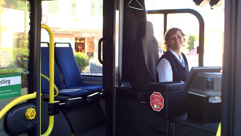 Mona ist Busfahrerin des Jahres. Sie sitzt am Steuer und lächelt in die Kamera. (Foto: SWR)
