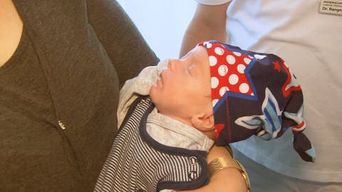 Ein Baby mit einer selbstgenähten Mütze von Sarah Karle (Foto: SWR)