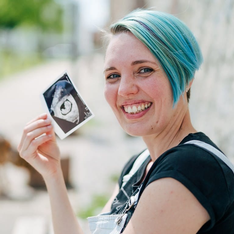 Tanja zeigt lachend ein Ultraschallbild ihres Kindes (Foto: SWR)