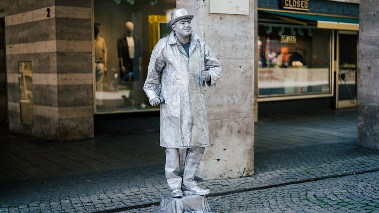 Straßenkünstler Paul versucht, sich als menschliche Statue Geld dazu zu verdienen. (Foto: SWR)