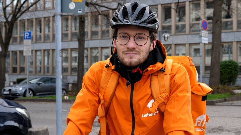 Fahrradkurier in orangener Jacke vom Lieferdienst Lieferando (Foto: SWR)