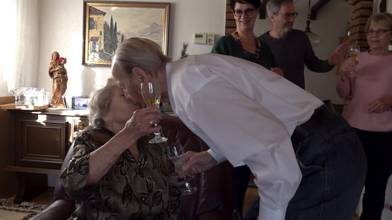 Ein Liebespaar küsst sich nach 75 Jahren Ehe.