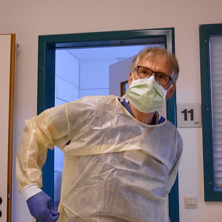 Krankenpfleger Christoph mit Maske und Schutzkleidung