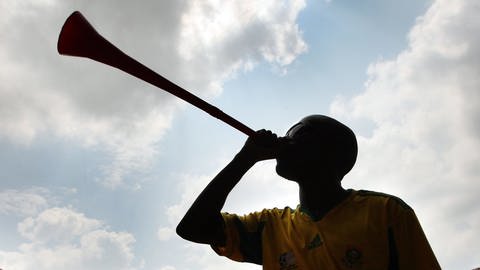 Mann benutzt Blasinstrument Vuvuzela (Foto: dpa Bildfunk, Picture Alliance)