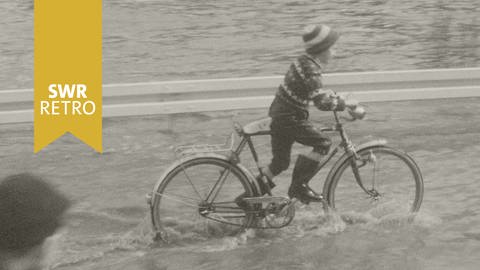 SWR Retro: Junge fährt auf dem Fahrrad durch Hochwasser (Foto: SWR)