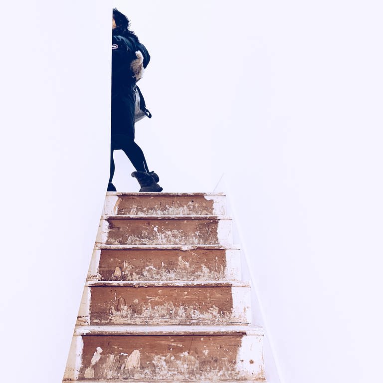Eine Frau geht eine Treppe hinauf (Foto: istock.com/Freya Batra)