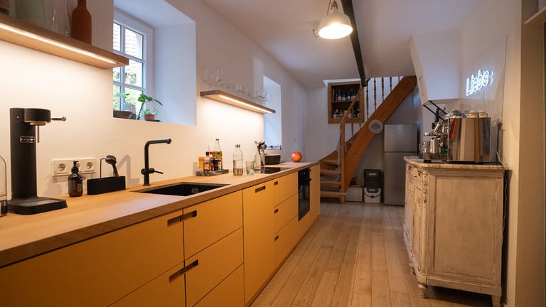 Eine senfgelbe moderne Küchenzeile nur mit Unterschränken und dicker Holzarbeitsplatte (Foto: SWR)