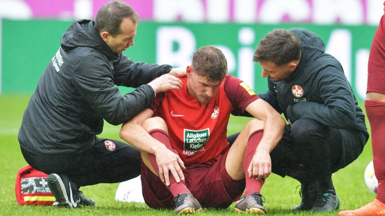 FCK-Spieler Kevin Kraus sitzt verletzt auf dem Spielfeld und wird behandelt. (Foto: IMAGO, IMAGO / Werner Schmitt)