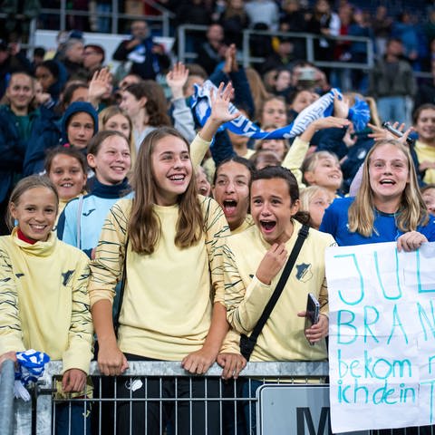Mädchen stehen im Hoffenheim-Fanblock und lachen (Foto: IMAGO, IMAGO / Eibner)