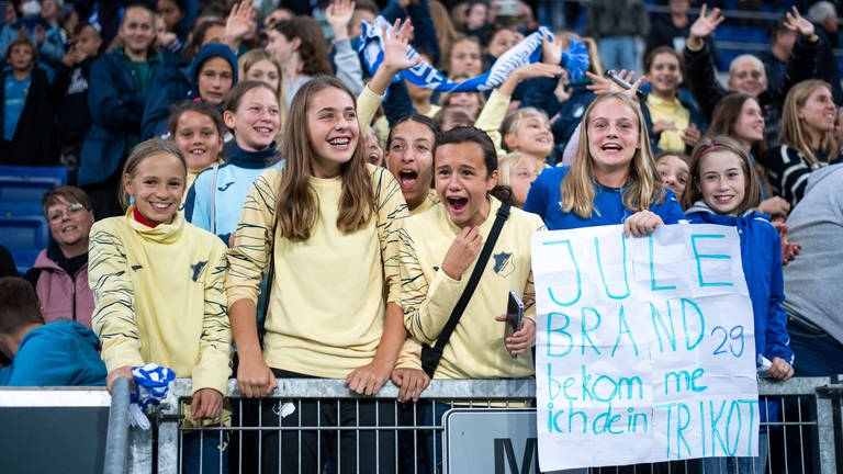 Mädchen stehen im Hoffenheim-Fanblock und lachen (Foto: IMAGO, IMAGO / Eibner)