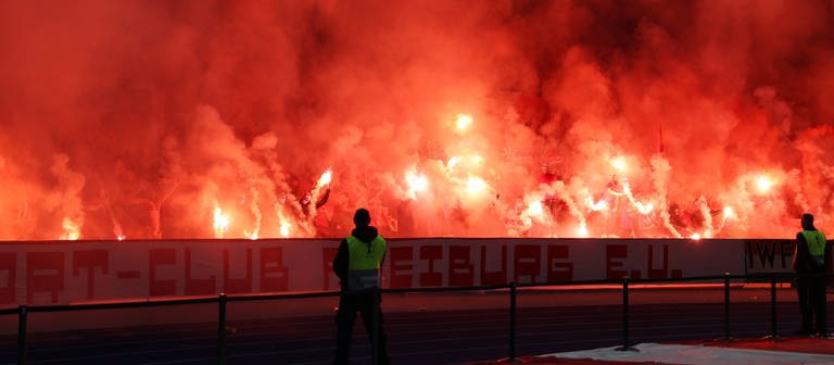 SC-Freiburg-Fans zünden rot leuchtende Bengalos beim DFB-Pokalfinale 2022 im Berliner Olympiastadion. (Foto: IMAGO, IMAGO/Pressefoto Rudel/Robin Rudel)