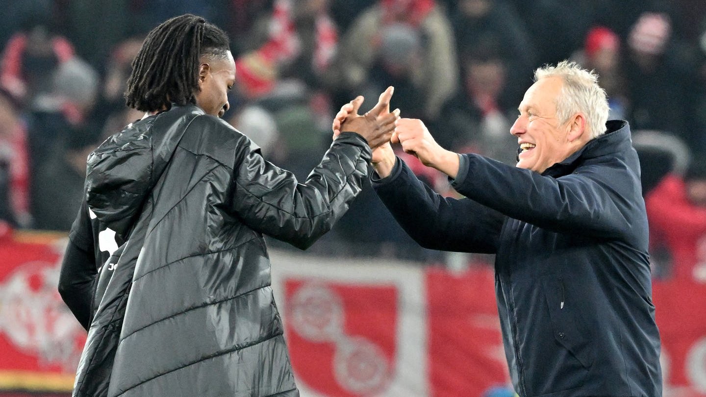 Jordy Makengo und Trainer Christian Streich feiern den Sieg ihres SC Freiburg beim 1. FC Köln. (Foto: IMAGO, IMAGO / Jan Huebner)