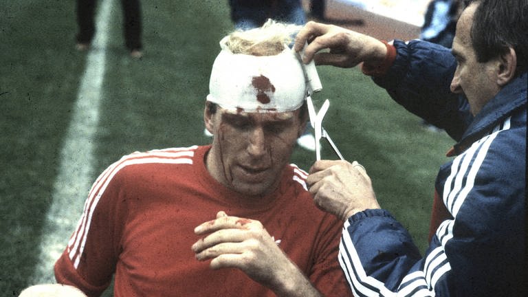 Dieter Hoeneß bekommt einen Verband um seine Platzwunde am Kopf (Foto: IMAGO, imago images / Horstmüller)