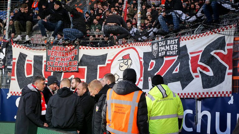 VfB-Präsident Claus Vogt diskutiert mit Fans wegen eines aufgehängten Banners
