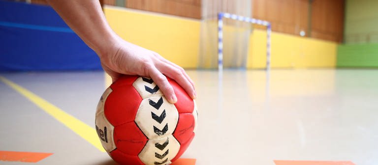 In einer Sporthalle liegt ein Handball auf dem Boden. (Foto: picture-alliance / Reportdienste, Picture Alliance)