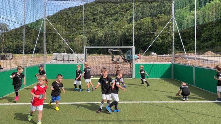 Kinder der Bambini-Mannschaft des SV-Dernau spielen Fußball. Der Wiederaufbau der Sportstätten im Ahrtal geht nach der Flut nur schleppend voran. 