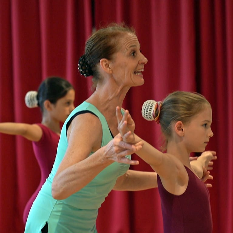 Die Ballettlehrerin korrigiert die Bewegungen der Kinder beim Training in der Tanzschule. (Foto: SWR)