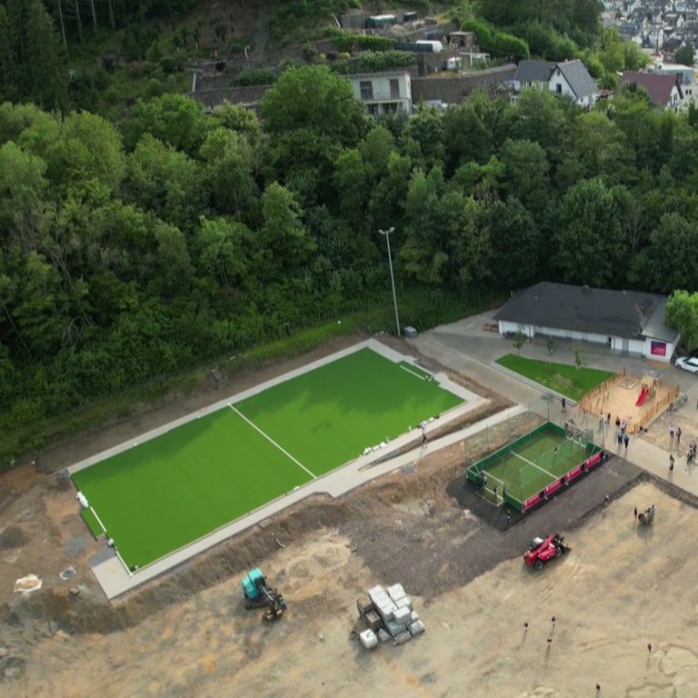 Umzäunter Fußballplatz in Dernau an der Ahr sowie ein neues Kleinspielfeld.