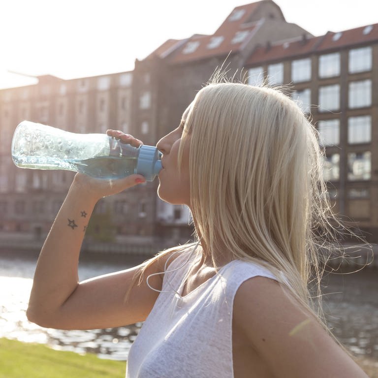 Frau trinkt beim Sport in der Hitze aus einer Wasserflasche (Foto: IMAGO, STPP)