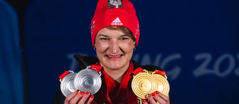 Forster lächelt in die Kamera und hält vier Medaillen in ihren Händen (Foto: IMAGO, Mika Volkmann)