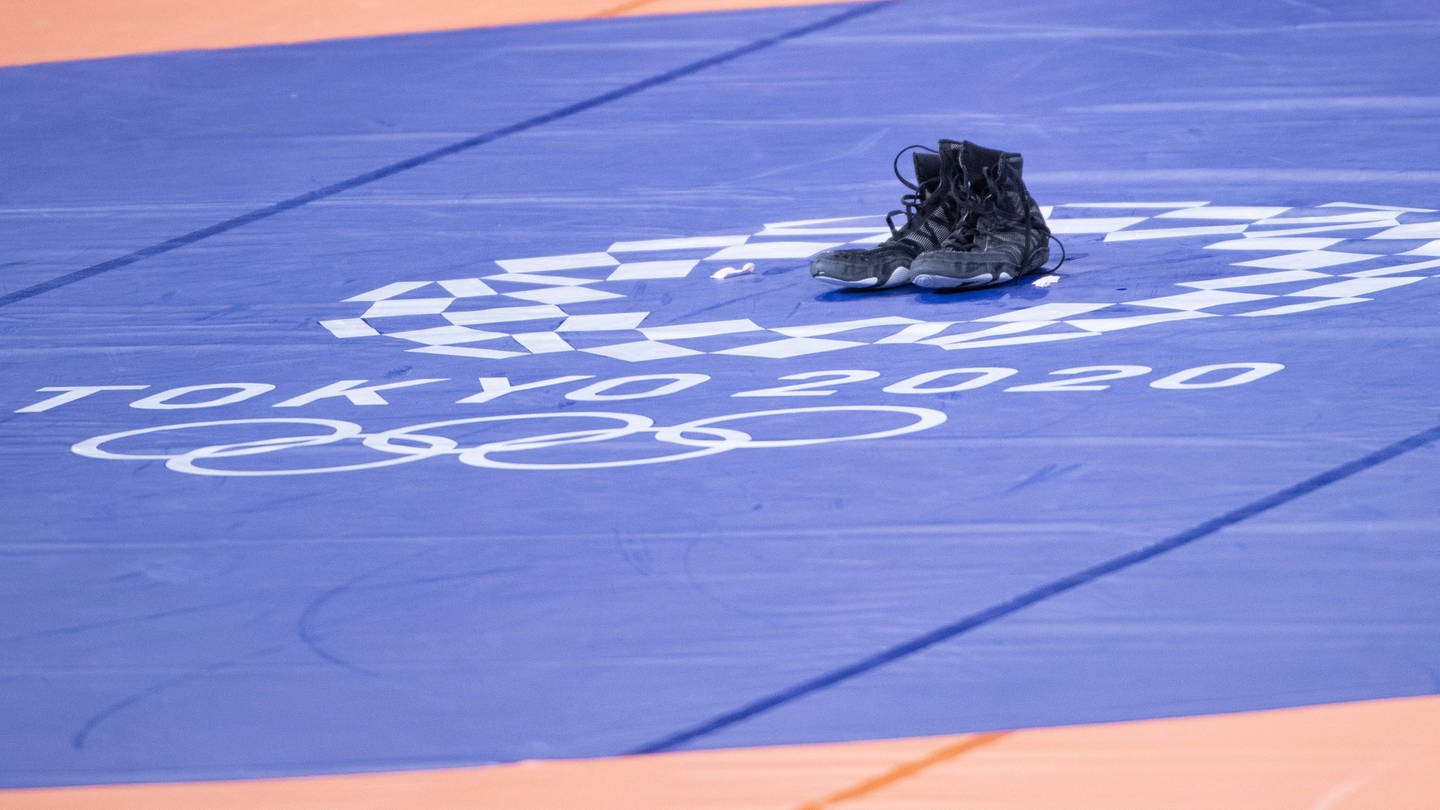 Die schwarzen Schuhe von Ringer Frank Stäbler stehen einsam und allein auf der Olympia-Matte von Tokio (Foto: IMAGO, AFLOSPORT)