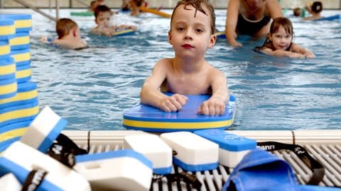 Kleinkind schwimmt mit Schwimmgürtel im Hallenbad. Schwimmkurse in RLP und BW sind rar. (Foto: IMAGO, Joker)