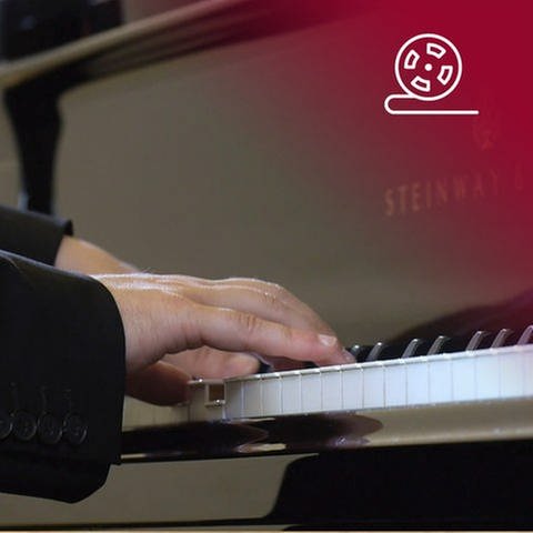 Standbild aus dem Dokumentarfilm Wir fangen ganz von vorne an: Hände von Pianist Igor Levit spielen auf einem Flügel, rotes Overlay mit Icon Filmrolle (Foto: SWR, bce films / ZDF/ ARTE)