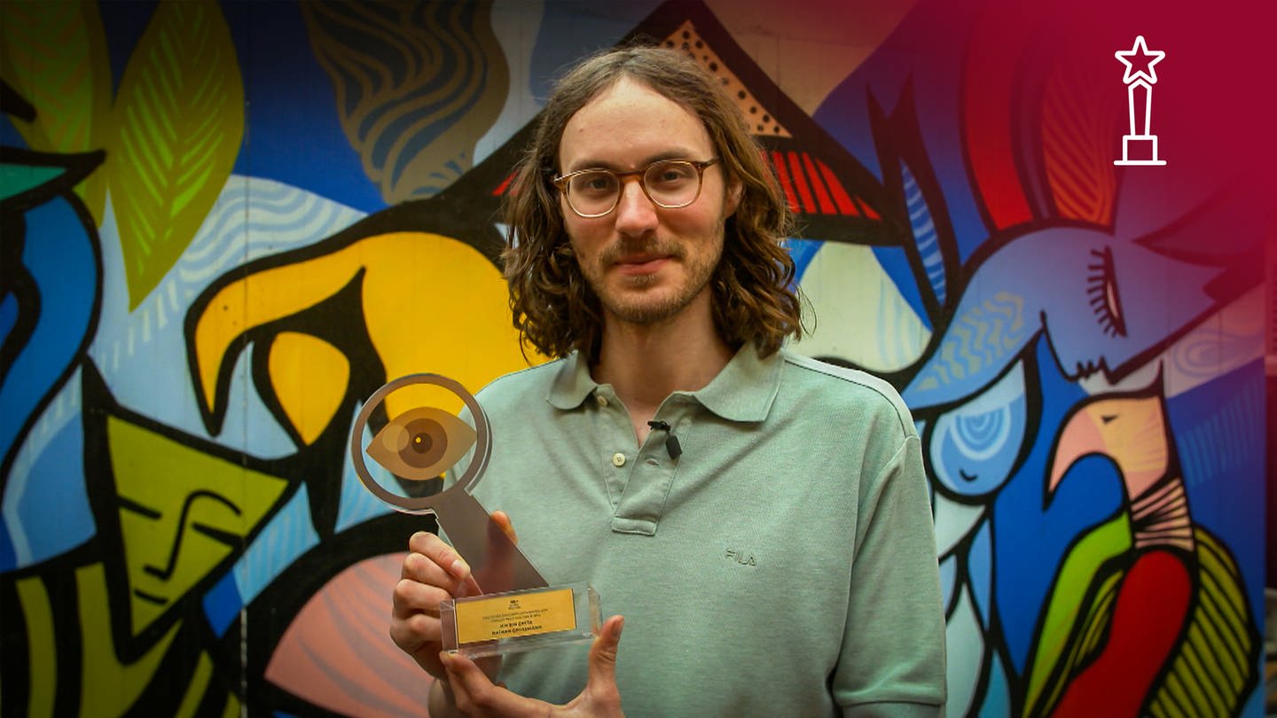Regisseur Nathan Grossman, Gewinner des Hauptpreises des Deutschen Dokumentarfilmpreises2021 hält den Laurel für seinen Dokumentarfilm 