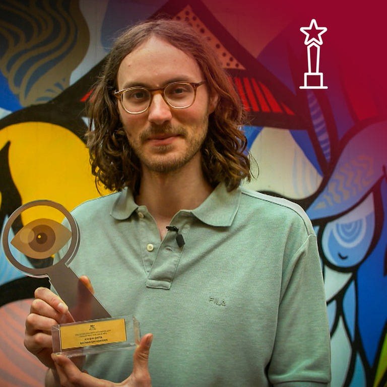 Regisseur Nathan Grossman, Gewinner des Hauptpreises des Deutschen Dokumentarfilmpreises2021 hält den Laurel für seinen Dokumentarfilm "Ich bin Greta" in den Händen. (Foto: SWR)